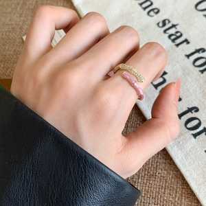 Detail of pink enamel and pavé zircon bamboo joint ring shown on a model's hand