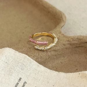 Detail of bamboo-shaped gold ring featuring pink enamel and micro-set zircon stones