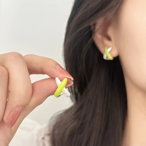 Cross-shaped X earrings featuring silver zircon stones and neon green enamel detail