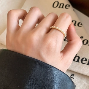 Bague élégante dorée avec perles et cristaux portée sur la main d'un modèle