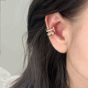 Minimalist gold triple-layer ear cuff featuring zircon stars on female model ear