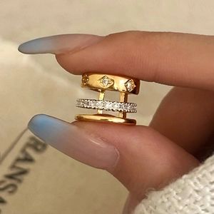 Detailed shot of triple-layer gold ring set with cubic zirconia on a warm background