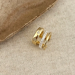Macro shot of gold three-layer ear cuff with diamond patterns and inlaid zircons