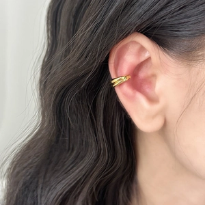 Close-up of minimalist double-layer gold-plated conch ear cuff on woman's ear