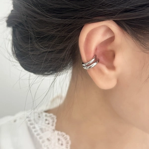 Close-up of minimalist silver double-layer ear cuff on a model wearing white lace