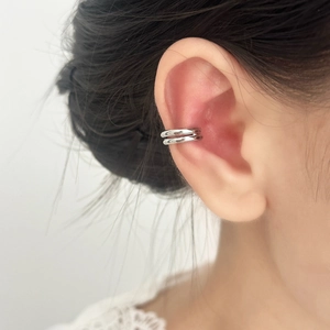 Vue détaillée d'une boucle d'oreille double couche en argent poli sur une oreille femme