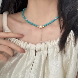 Elegant beaded necklace featuring blue turquoise, white pearls and gold chain tassel