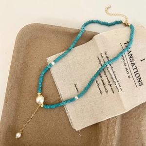 Bohemian turquoise bead necklace with white pearls and a gold Y-shaped pendant drop
