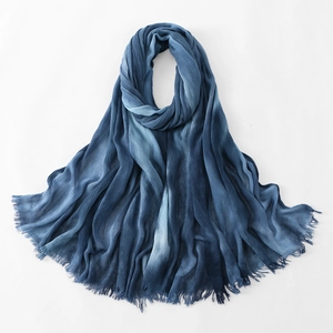 Macro detail of blue gradient cotton scarf showing crinkle texture and frayed fringe edges
