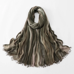 Detail of earth-tone pleated scarf featuring fine fringe edges and textured gradient fabric