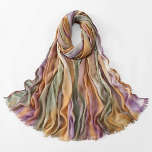 Detail of colorful pleated scarf with gradient stripes and frayed tassel edge