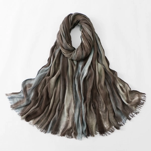 Detailed close-up of gradient stripes on a wrinkled cotton scarf with soft fringe