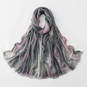 Close-up of pleated gradient scarf featuring elegant grey-pink tones and fringe edges