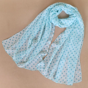 Detailed texture of light blue polka dot chiffon scarf with soft fabric drapes