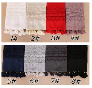 Detail showing eight colors of embroidered lace scarves with elegant tassel fringe