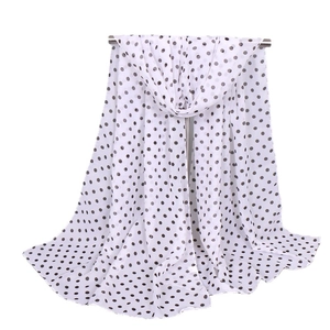 Elegant white chiffon scarf with black polka dots hanging on a minimalist silver rod