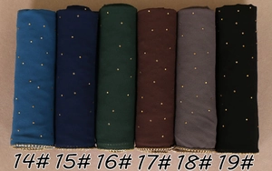 Détail de foulards en mousseline perlée avec strass dorés et bords perlés en six couleurs
