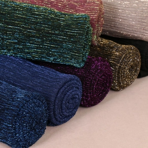Detail of pleated metallic yarn scarves in multiple colors like royal blue and gold