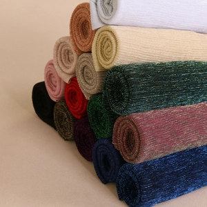 Macro view of metallic gold thread scarves showing rib knit texture and vibrant colors
