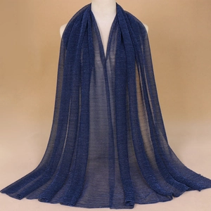 Detail of dark blue sheer shawl with gold thread shimmer on a mannequin display