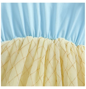 Détail du tissu satiné bleu avec tulle jaune et motif de losanges dorés pailletés