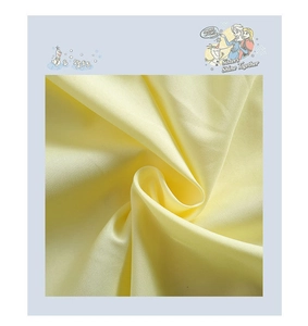 Détail du tissu jaune clair aspect soie avec texture lisse et drapé souple