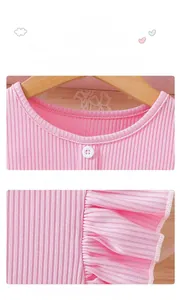 Detail of pink girls dress showing round neck with button and ruffled elastic cuffs