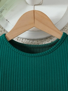 Close-up of dark green ribbed knit neckline with fine stitching and soft texture