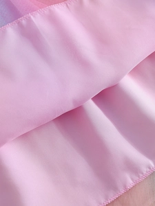 Vue détaillée du satin rose et du tissu en maille multicouche d'une robe de princesse