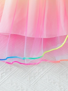 Detail van roze gelaagde tule rok met kleurrijke gevlochten regenboog afwerking
