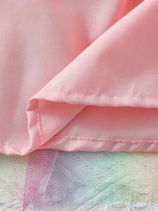 Detail van roze satijn en regenbooggaas met glitters voor een meisjesjurk