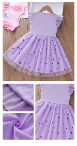 Détail du tissu en maille violette avec sequins colorés et motif licorne imprimé