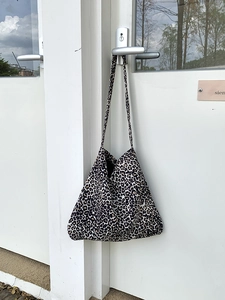 Detail view of large corduroy leopard print tote bag hanging on a door handle