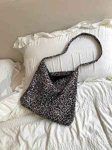 Macro shot of high-capacity corduroy leopard print tote bag texture on soft white fabric