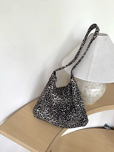 Detailed texture of leopard print corduroy tote bag in a warm aesthetic interior setting