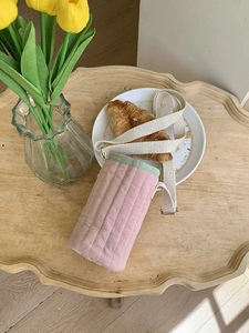 Dettaglio borsa trapuntata per borraccia rosa e verde con tracolla crema regolabile