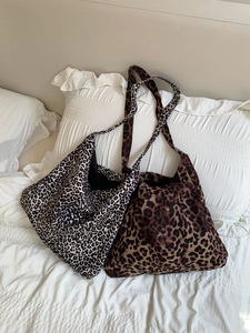 Large capacity corduroy leopard print tote bags in two colors on a soft white bed