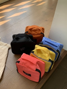 Detail of colorful nylon makeup bags with top handles and stylish logo patches
