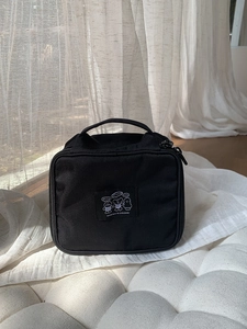 Close-up of black nylon makeup bag with cute cartoon bears and metal dual zippers