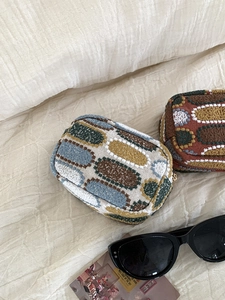 Detailed close-up of embroidered rectangular pouches with colorful geometric patterns