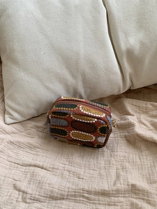 Detail of vintage jacquard coin purse with colorful oval patterns and gold metal zipper
