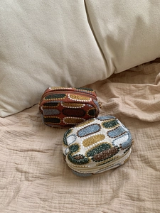 Macro shot of two vintage geometric embroidered coin purses with golden metal zippers