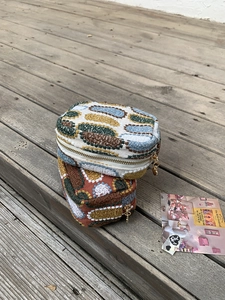 Close-up of embroidered mini coin purses with knitted texture and heart-shaped metal zippers