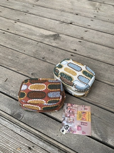 Close-up of small knitted coin purses with geometric jacquard pattern and metal zipper