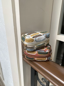 Detail of embroidered mini pouches with heart-shaped zipper pull and floral patterns
