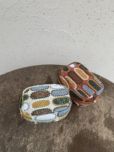 Close-up of embroidered mini pouches with colorful patterns and metallic gold zippers