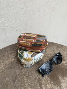 Close-up of ethnic embroidered mini pouches with colorful patterns and metal zippers