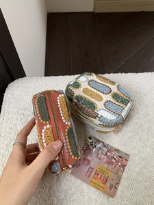 Detail view of retro jacquard embroidery mini pouch with colorful oval patterns and gold zipper
