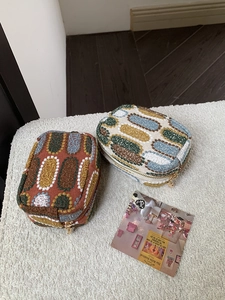 Close-up of vintage embroidered coin purses with thick fabric texture and gold heart zippers