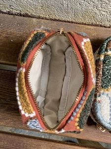 Close-up of embroidered mini pouch showing floral weaving patterns and inner canvas lining